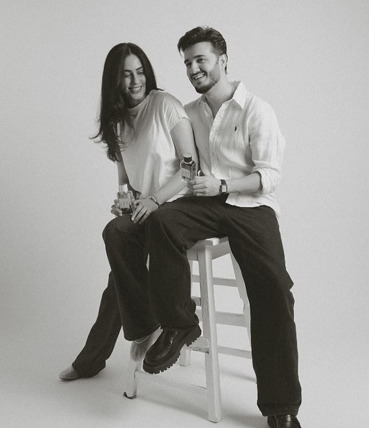 A couple sharing JAF perfumes on a studio stool in black and white