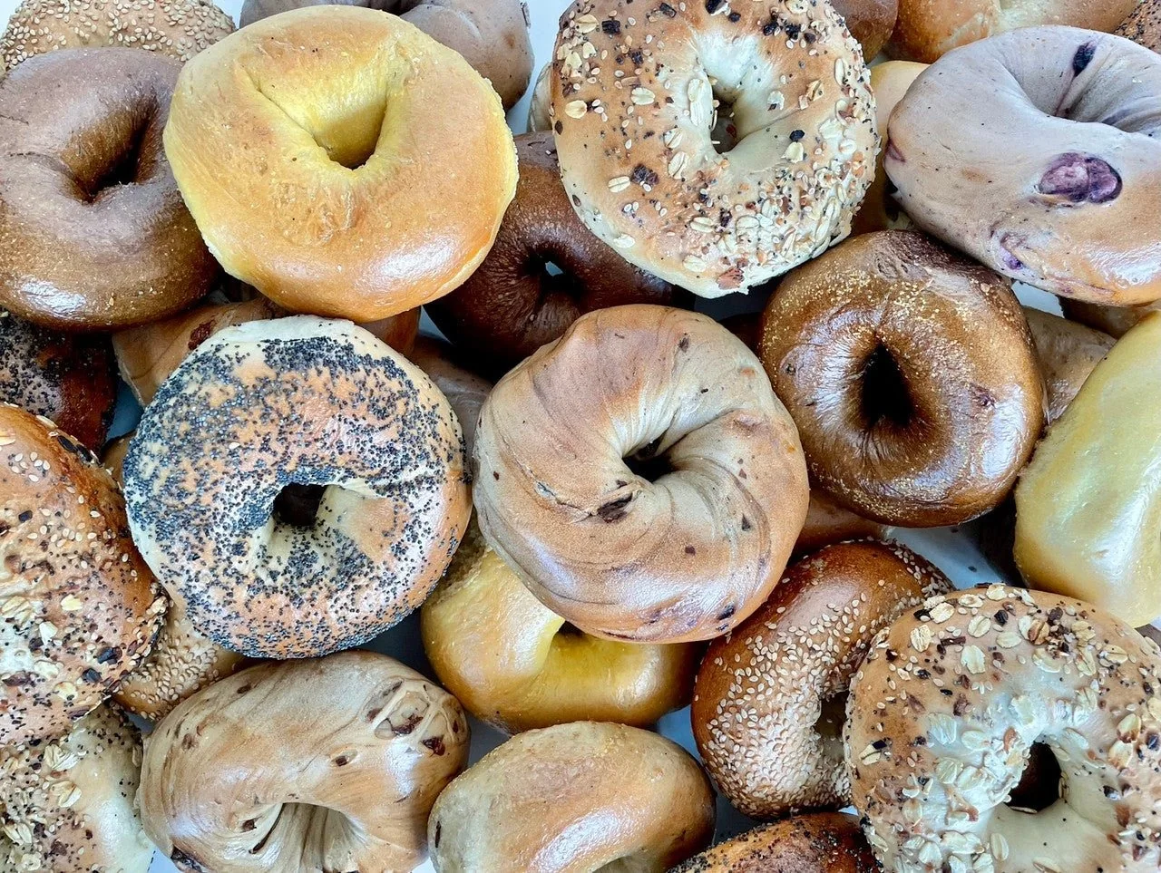 A pile of fresh bagels with poppy, sesame and everything toppings