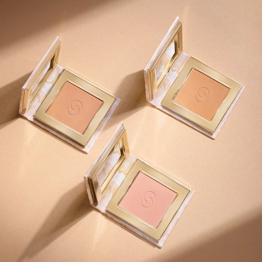 Three compact powders on a warm peach background