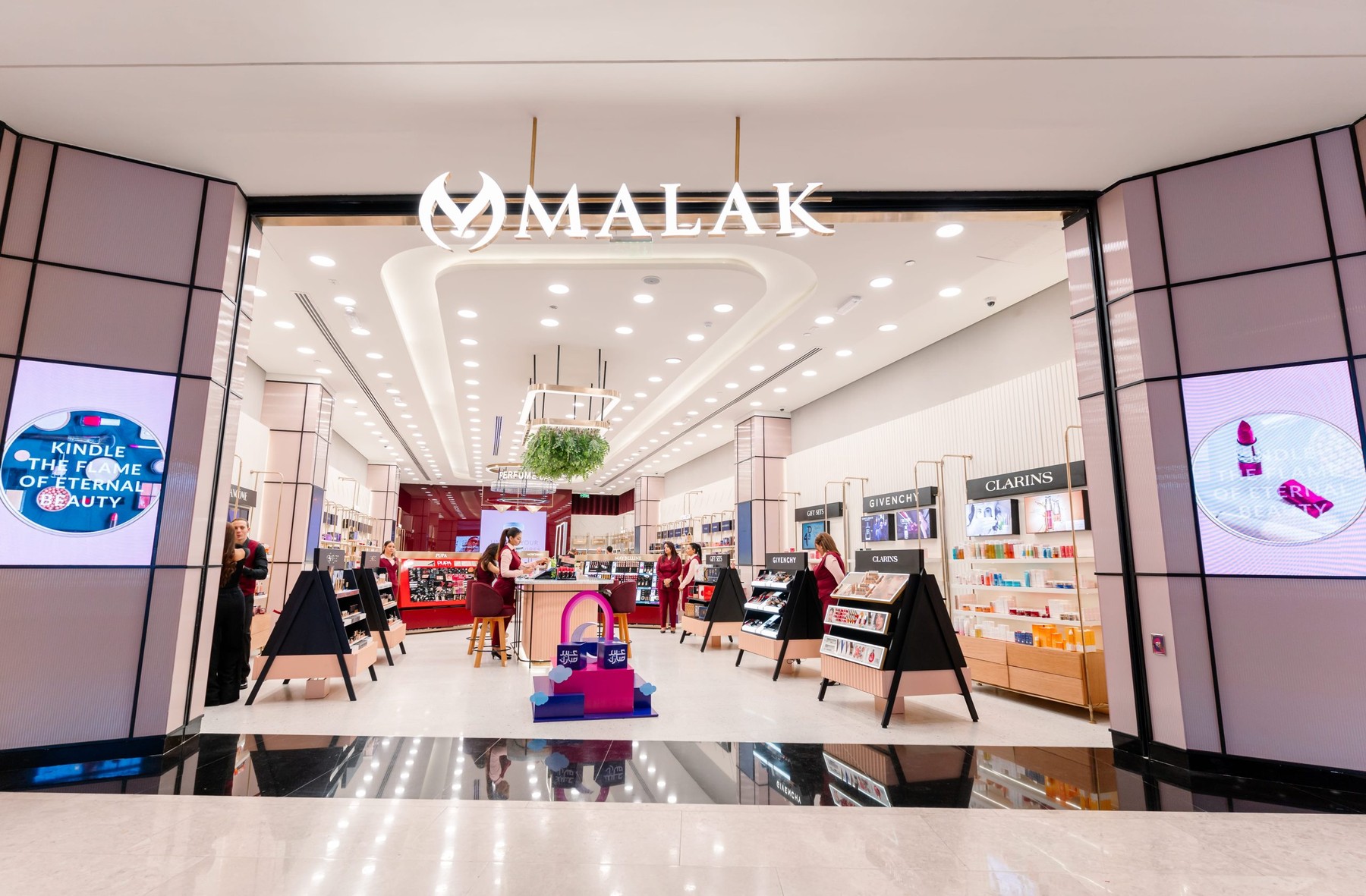 A Malak storefront with its sign above a bright, open beauty floor