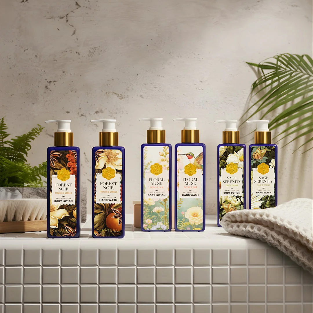 CoNatural bath and body bottles lined up on a tiled bathroom ledge