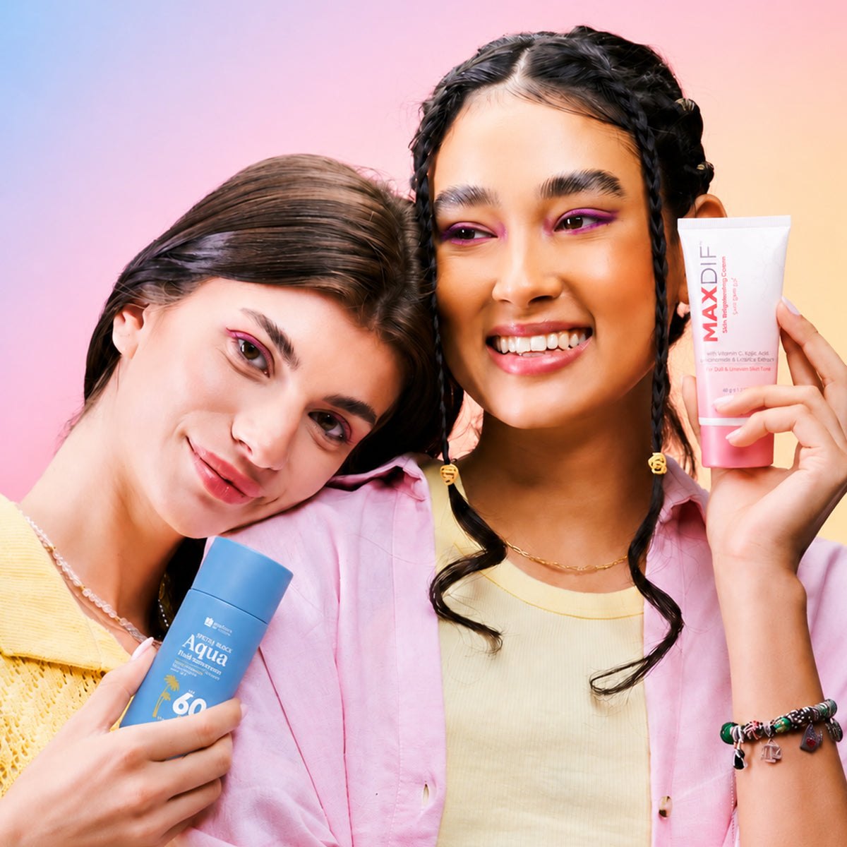 Two women holding Jenpharm Aqua sunscreen and Maxdif cream