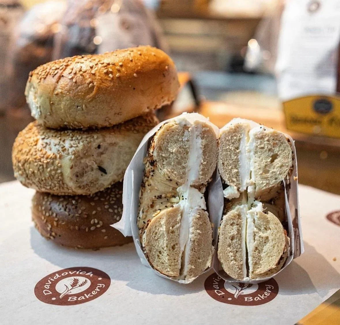 Halved everything bagels filled with cream cheese on Davidovich Bakery paper